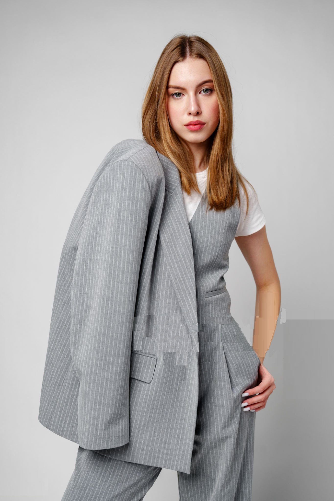 Woman in Gray Suit and White Shirt posing in studio on gray background Woman in Gray Suit and White Shirt posing in studio on gray background