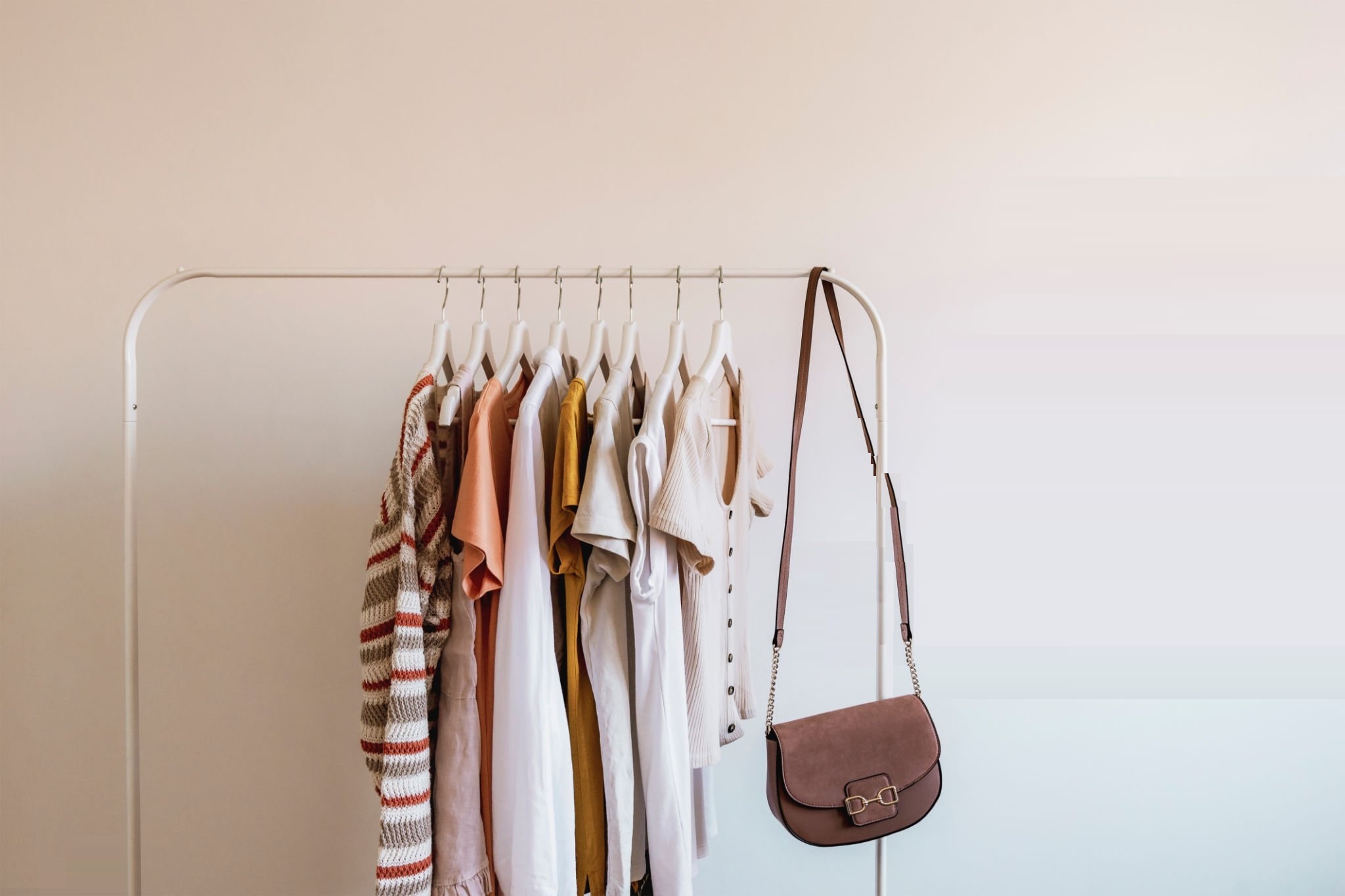Rack with stylish women's summer clothes and handbag. Concept for shopping store, beauty, fashion.